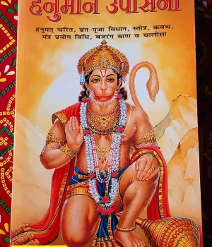'Hanuman Upasana' in Hindi, featuring a vibrant illustration of Lord Hanuman kneeling with a mace, set against an orange background."