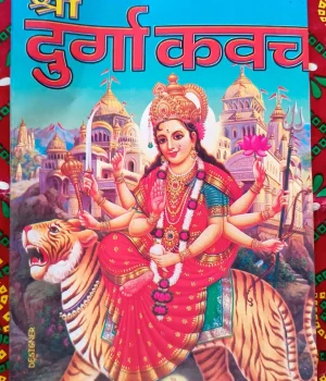 A full-color devotional image on a book cover. The central figure is the Hindu goddess Durga, depicted with multiple arms, riding a tiger. She holds various weapons and symbols, including a sword, trident, and lotus flower. She wears a crown, a red sari, and elaborate jewelry. In the background, several ornate temples or palaces with golden domes are visible against a blue sky. At the top of the image, the title 'श्री दुर्गा कवच' (Shri Durga Kavach) is written in large red Hindi script with a yellow outline, above the illustration. A website URL, 'WWW.TODAYU56.COM', is partially visible at the bottom left, and 'DESIGNER' is written vertically on the left side." Apan Mithila www.todayuse.com