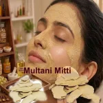A woman applying a thick, creamy grey-brown paste of Multani mitti face pack