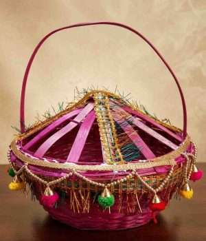 Handmade-woven bamboo basket (known as a Phuldali or Saji). Red colored basket is a staple of Mithila culture in Bihar, India, and is primarily used to carry flowers for religious rituals. The basket features a conical, ventilated lid adorned with gold tinsel, colorful embroidery, and hanging decorative tassels with small metallic bells, topped with a tall, curved handle for easy carrying. todayuse or apan mithila